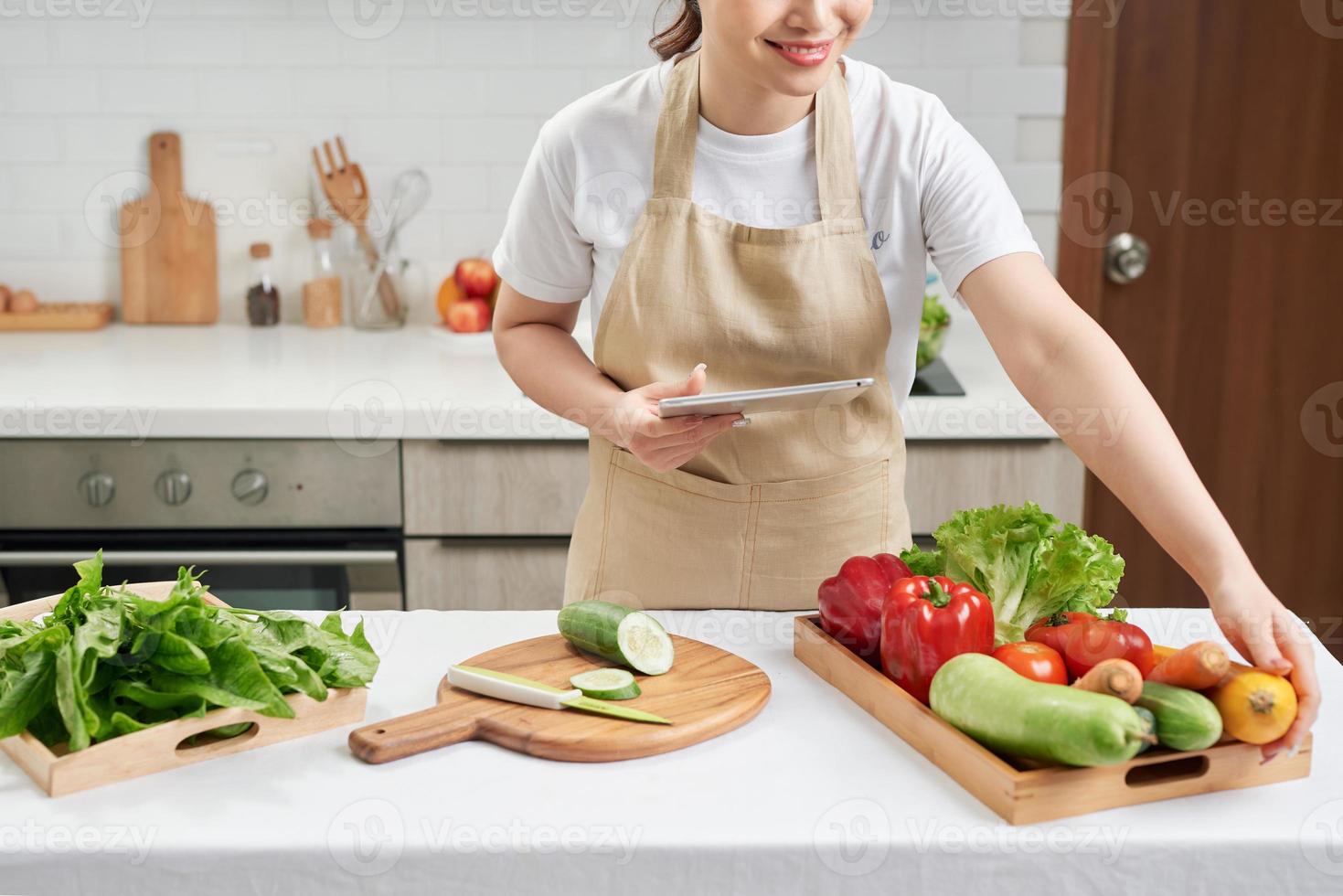 bela dona de casa senhora segura tablet digital procurando receita internet palestra master class cozinhar delicioso jantar em família foto