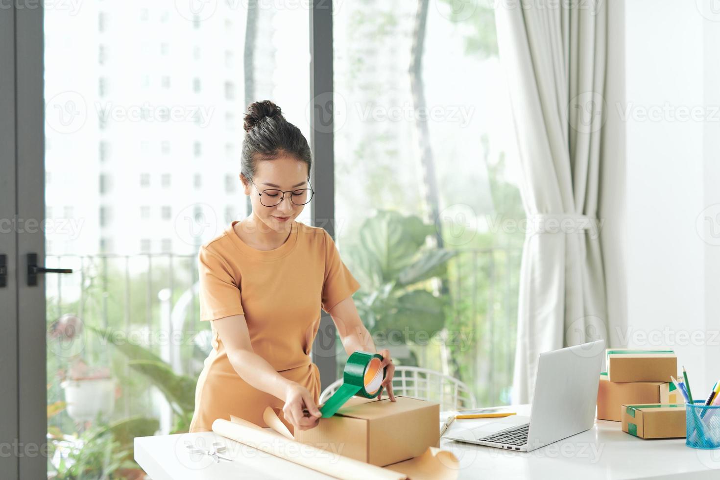 comerciantes on-line embalando itens em caixas de papel foto