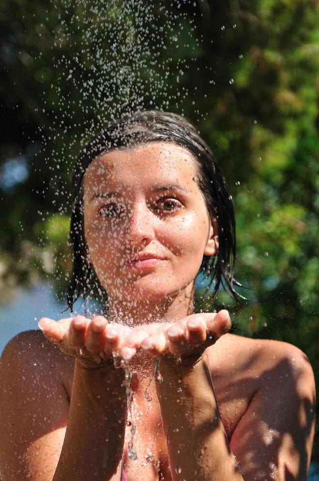 jovem mulher bonita relaxante sob o chuveiro foto