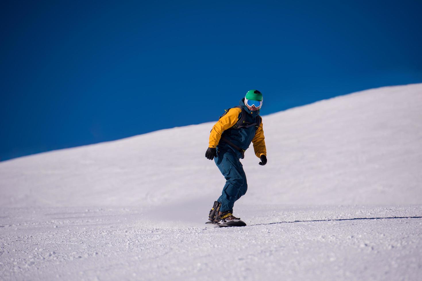 snowboarder descendo a ladeira e andar de estilo livre foto