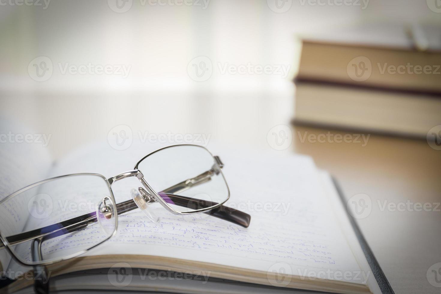 óculos colocar no notebook na mesa de madeira foto