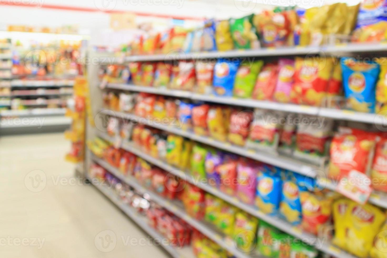 prateleiras de loja de conveniência de supermercado com salgadinho de batata desfocar fundo abstrato foto