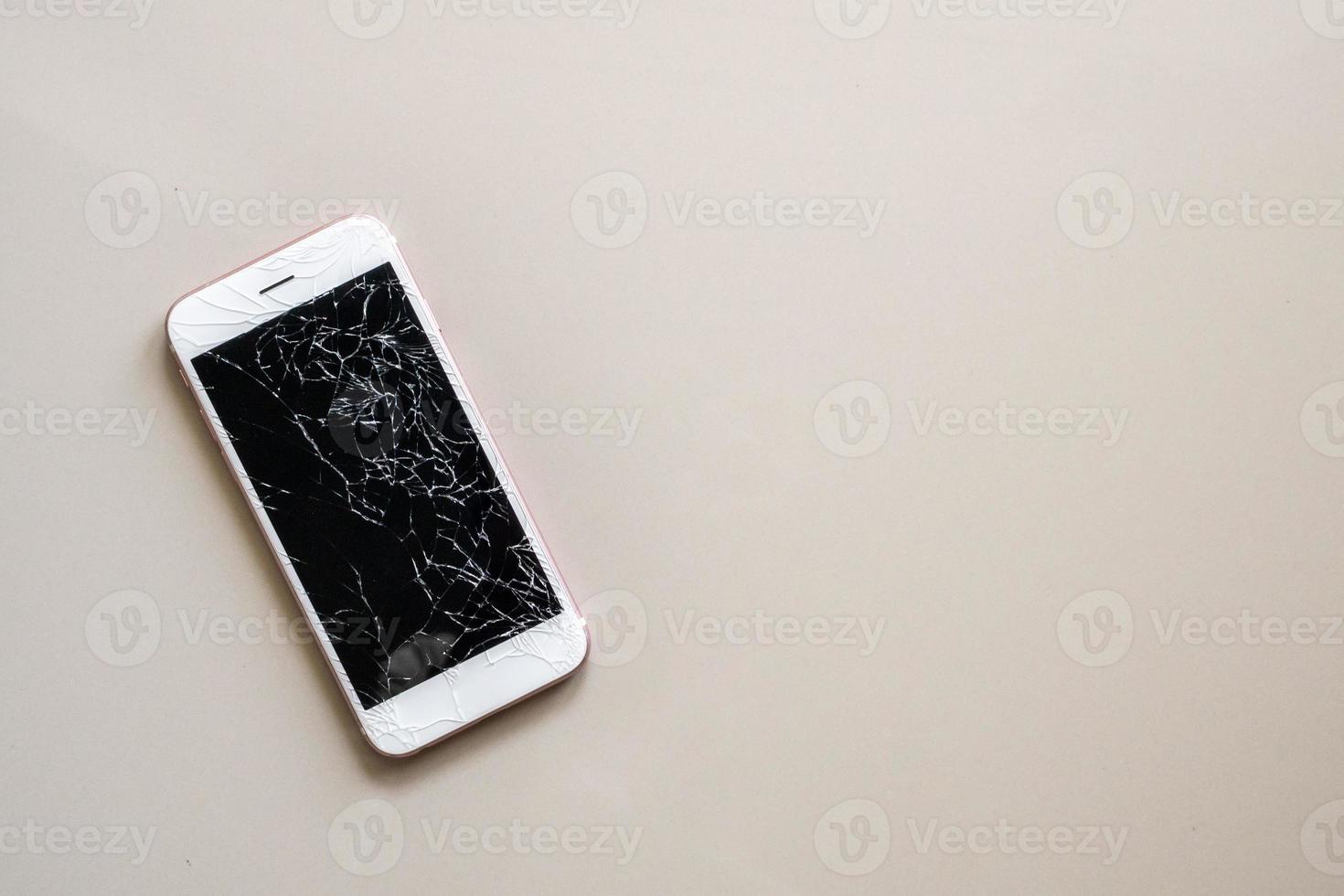 vidro quebrado da tela do celular no fundo do piso de ladrilho foto