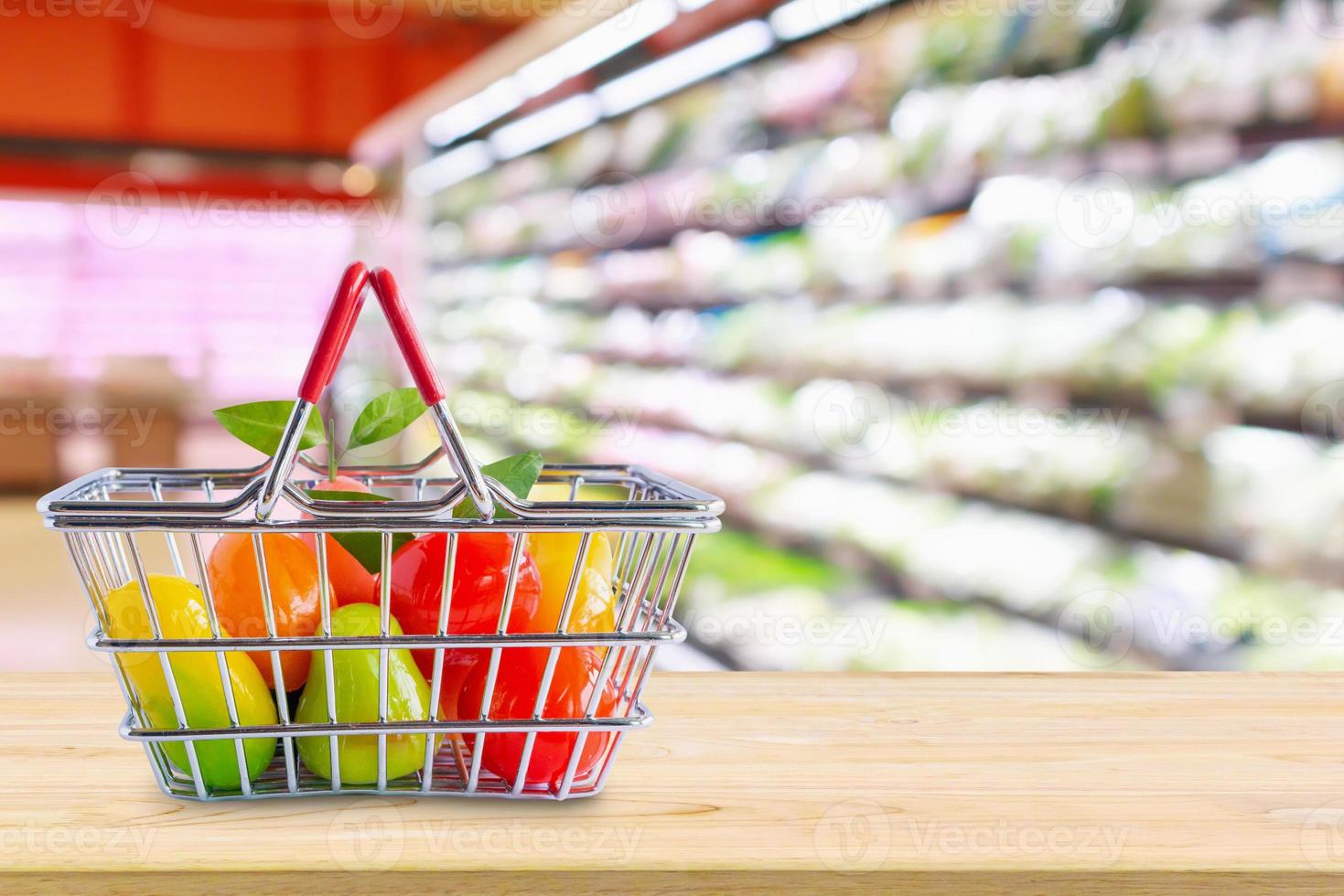 cesta de compras com frutas na mesa de madeira sobre mercearia supermercado desfocar o fundo foto