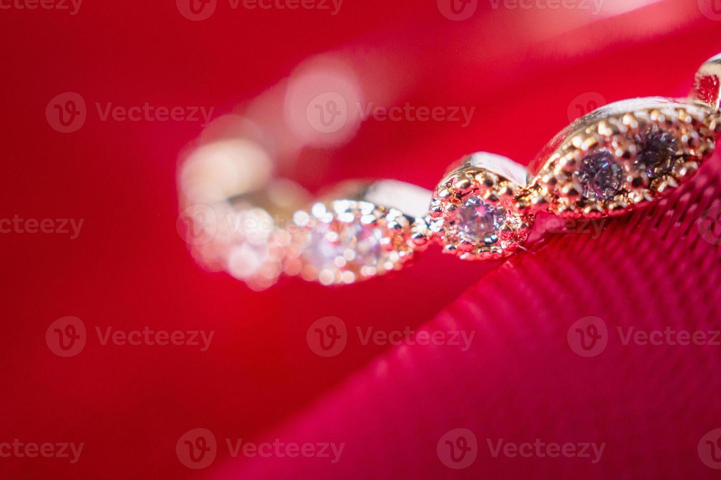 anel de ouro rosa de luxo de joias com pedra preciosa de safira no fundo de textura de tecido vermelho foto