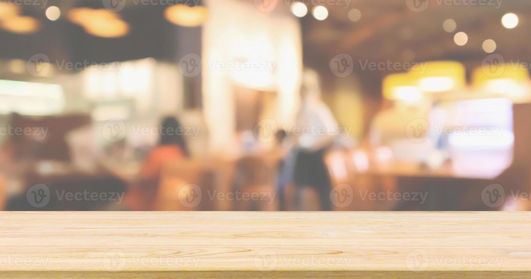 tampo da mesa de madeira com restaurante café ou interior de cafeteria com pessoas abstratas desfocadas desfocar o fundo foto