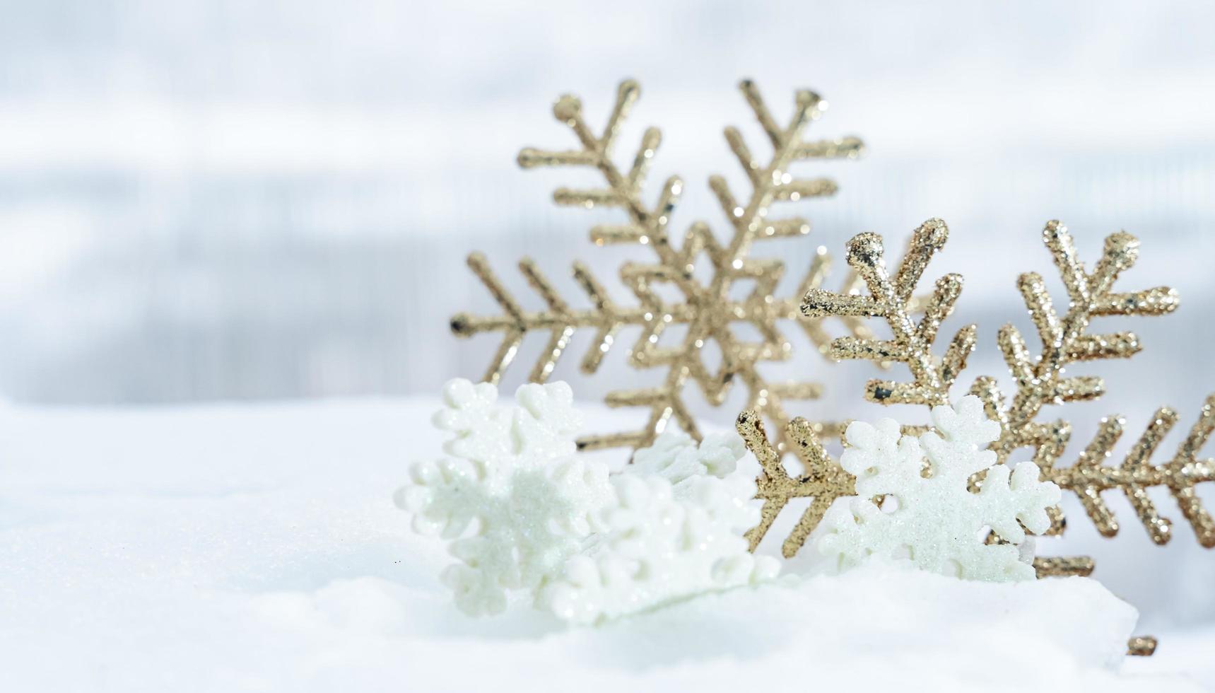 natal de inverno - bolas de natal com fita na neve, conceito de férias de inverno. bolas vermelhas de natal, bolas douradas, decorações de pinho e flocos de neve em fundo de neve foto