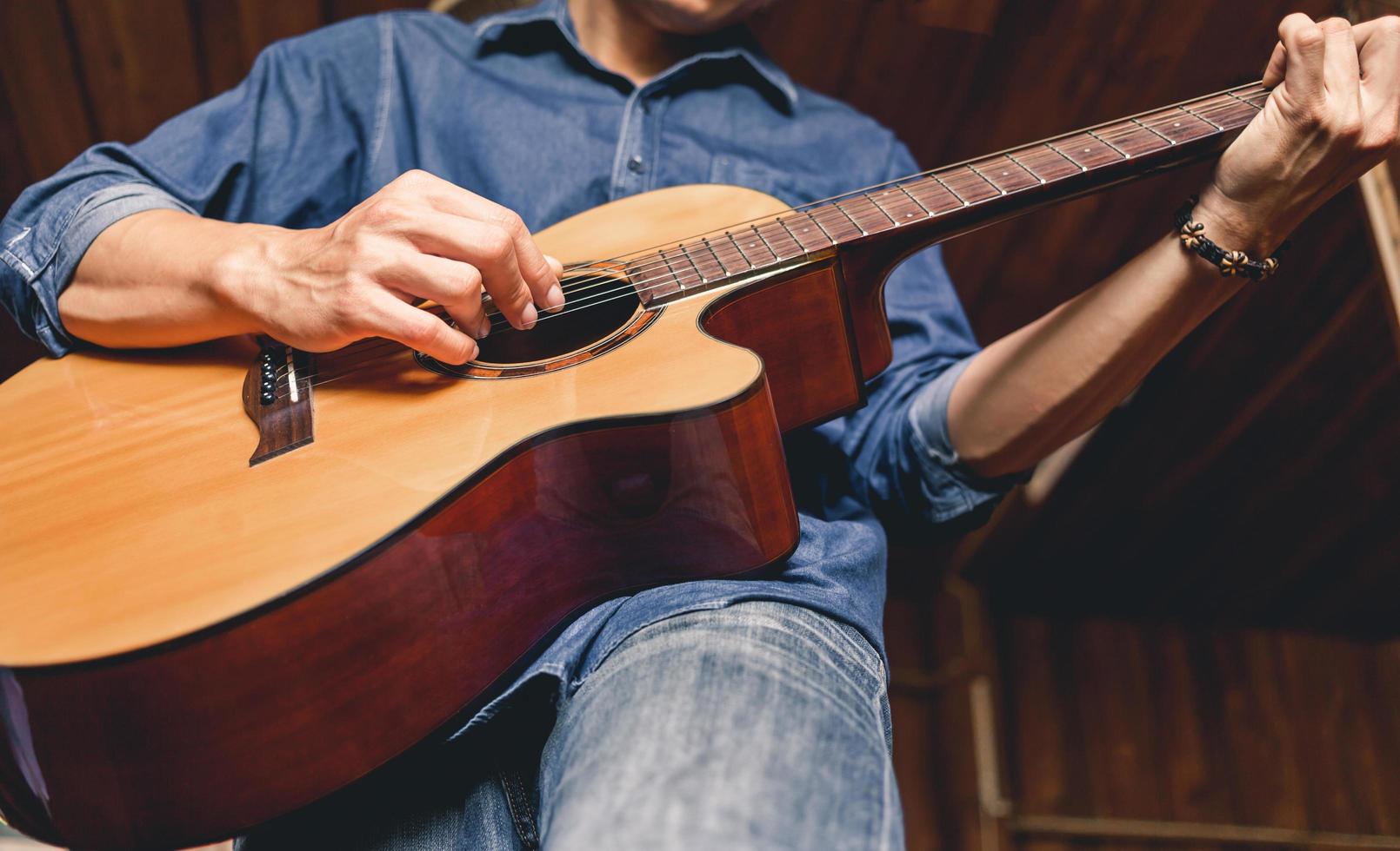 hipster de músico masculino asiático tocando violão ou praticando violão para lazer ou idéias de hobby para férias relaxantes em casa. foto