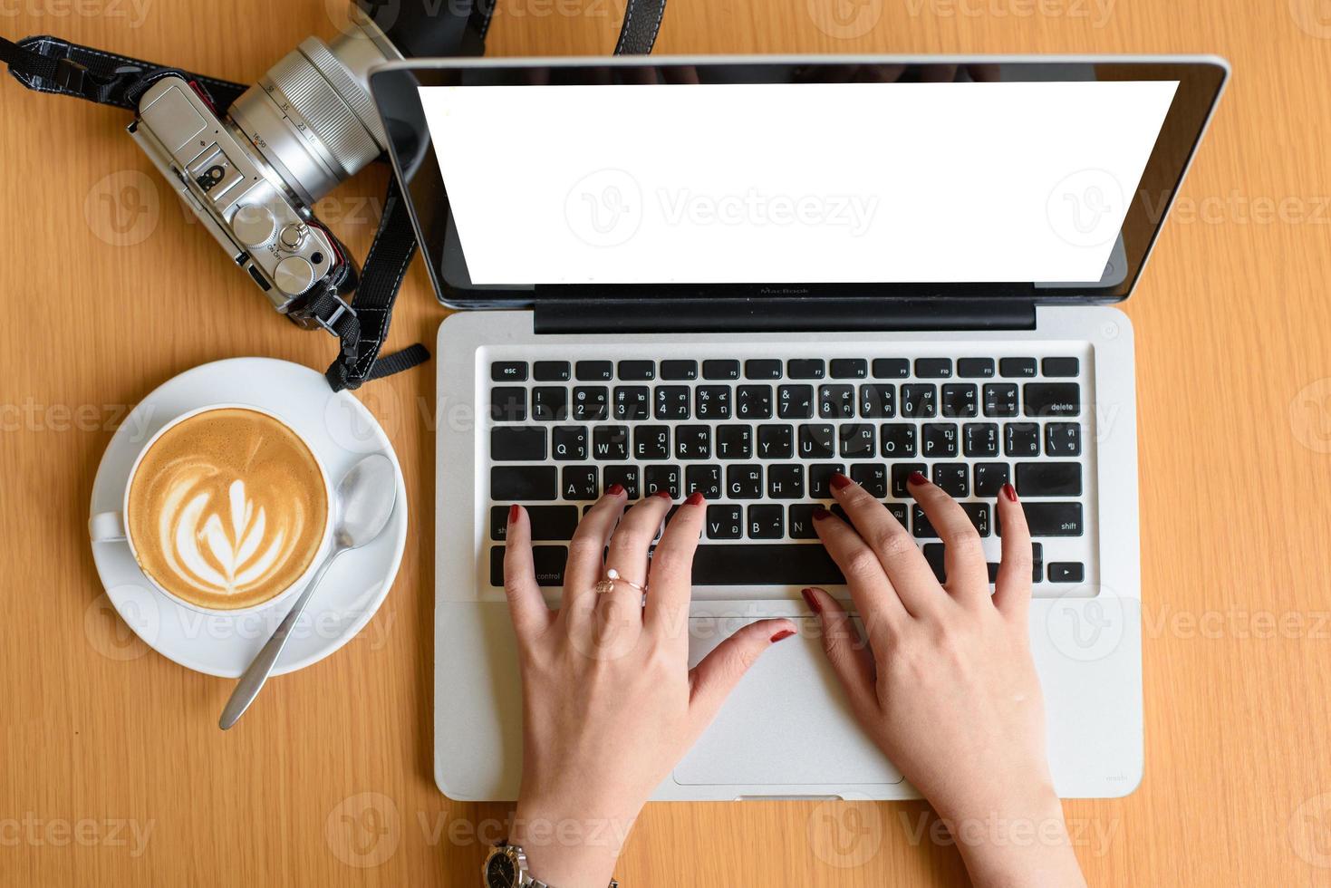 mãos femininas digitando em um teclado de laptop com tela isolada e café relaxam o tempo foto