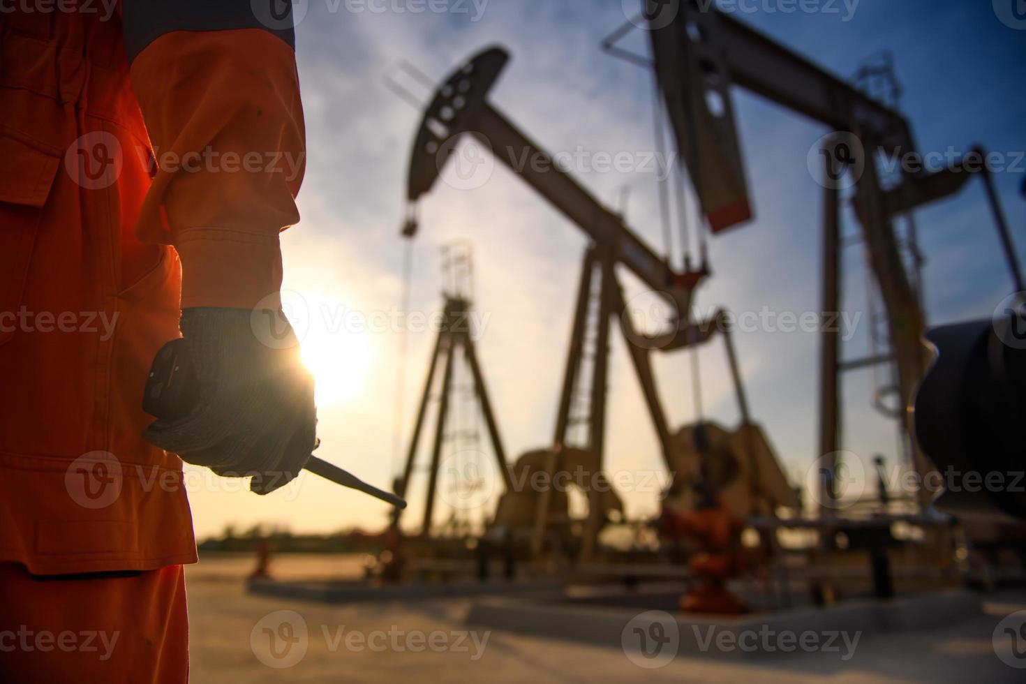 silhueta de trabalhadores do petróleo trabalhando à noite e belo pôr do sol. foto