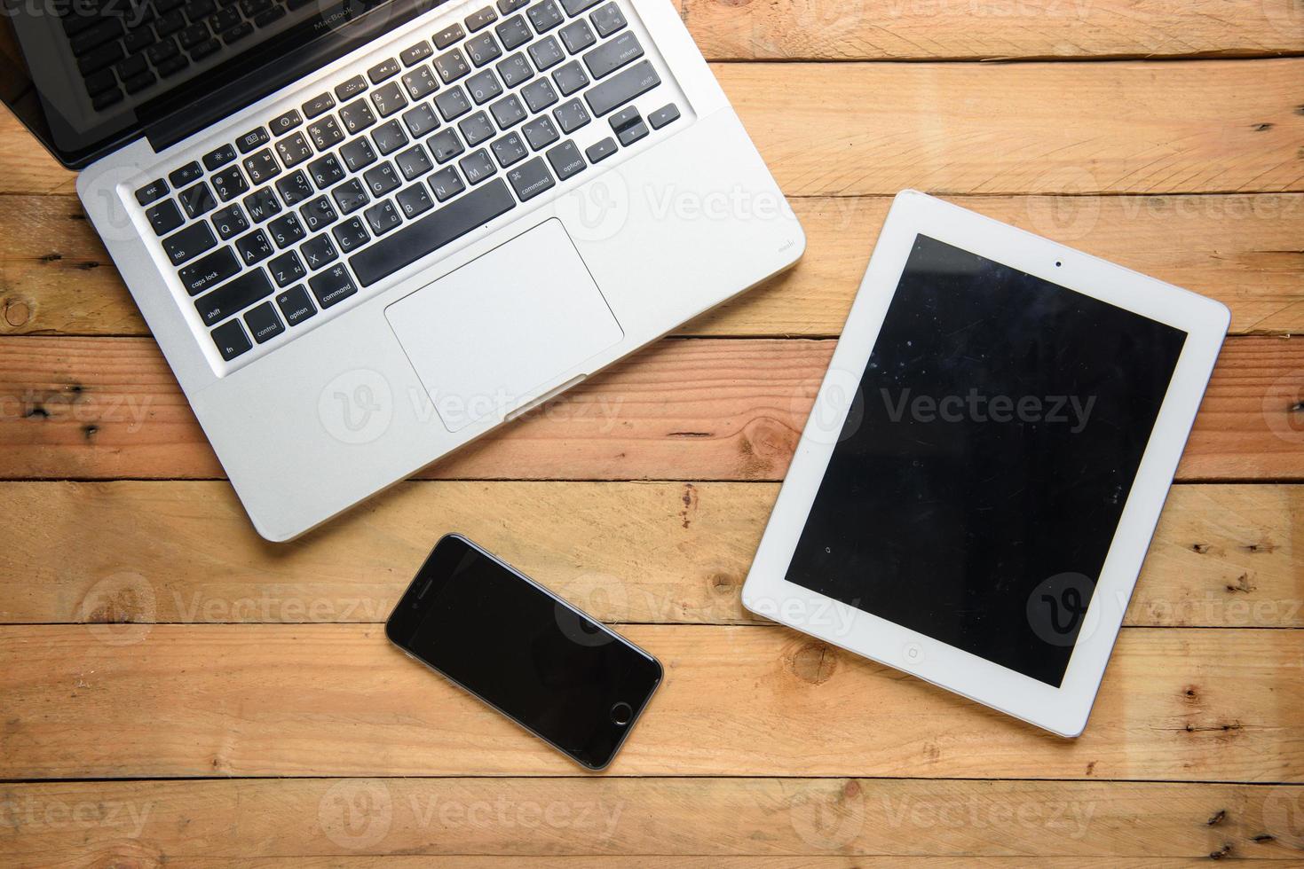 tablet de maquete comunicador semelhante ao dispositivo eletrônico moderno ipad em fundo de madeira foto