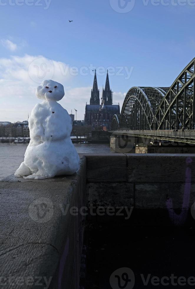 um boneco de neve em colônia, alemanha, com a famosa catedral ao fundo foto