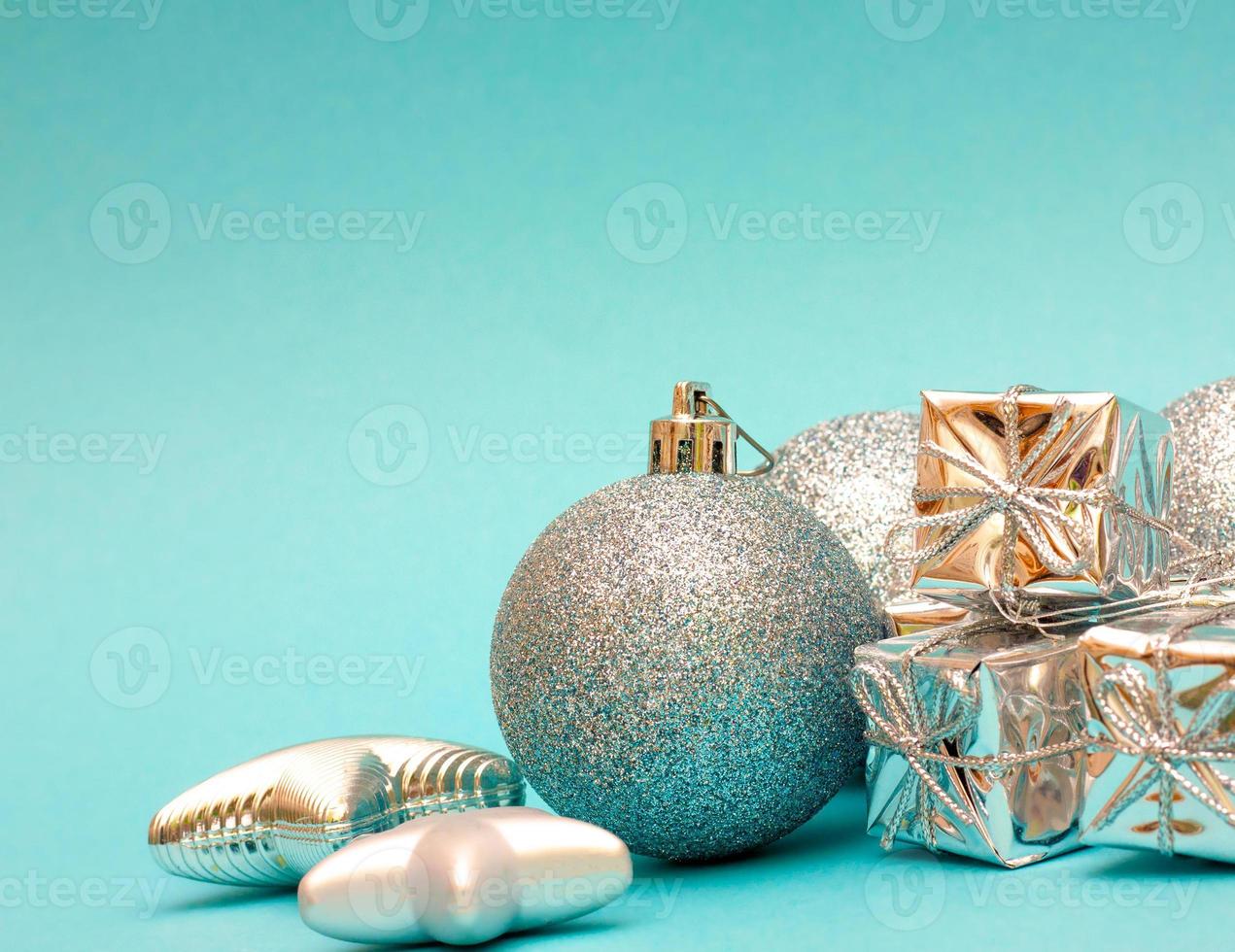 composição de ano novo. presente, decorações de prata de natal, bola,  estrela em um fundo azul. vista lateral, lugar para texto. conceito de  férias. brinquedos para a árvore de natal, pinho 11840565