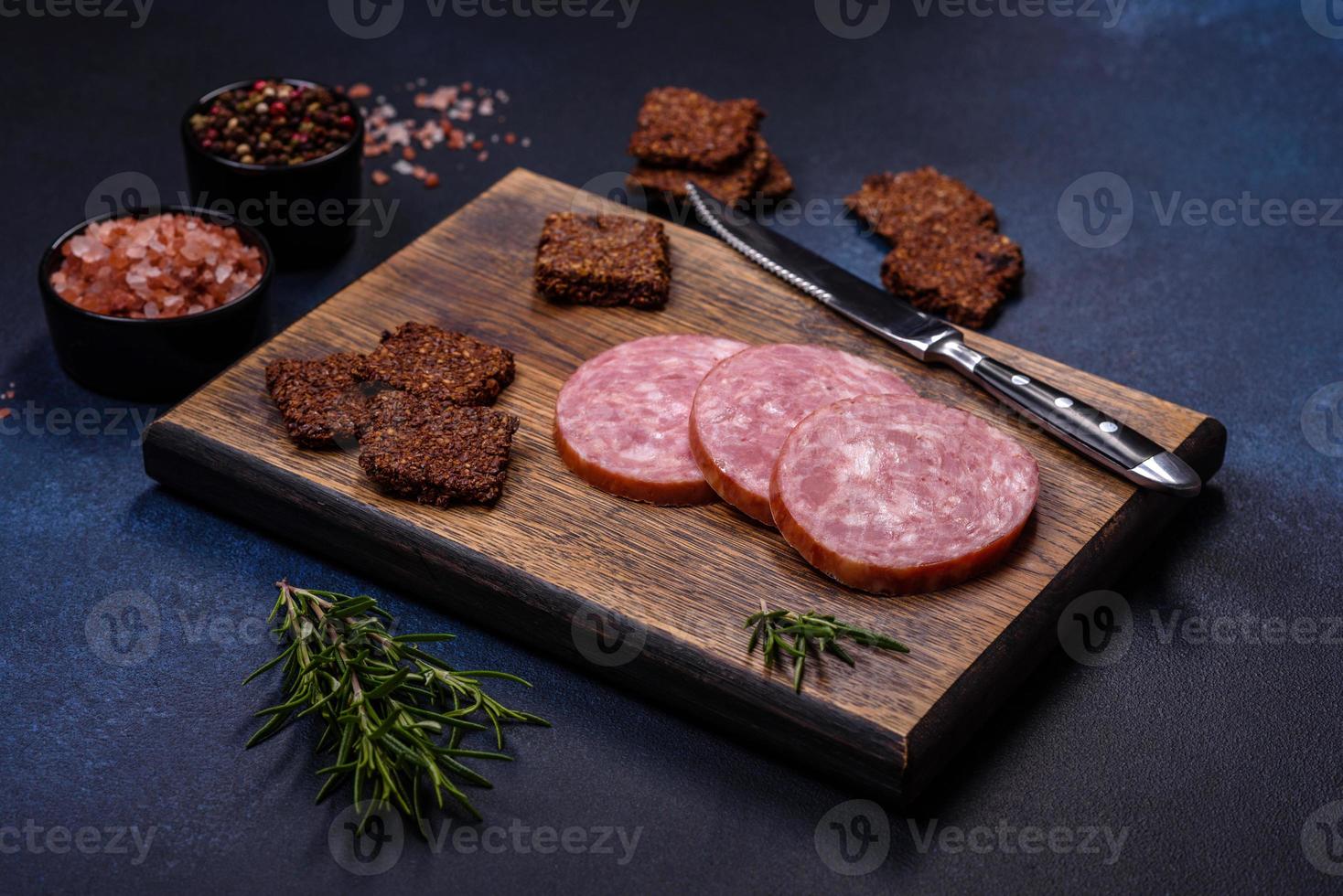 deliciosa salsicha defumada fresca cortada com fatias em uma tábua de madeira foto