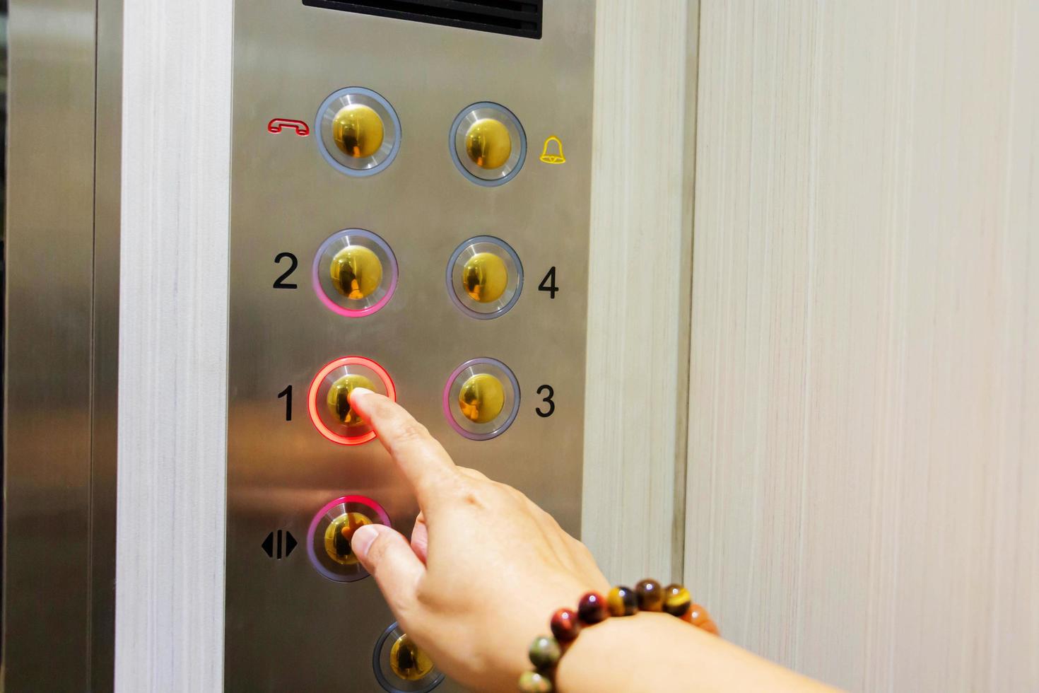botão de toque de mão no elevador foto