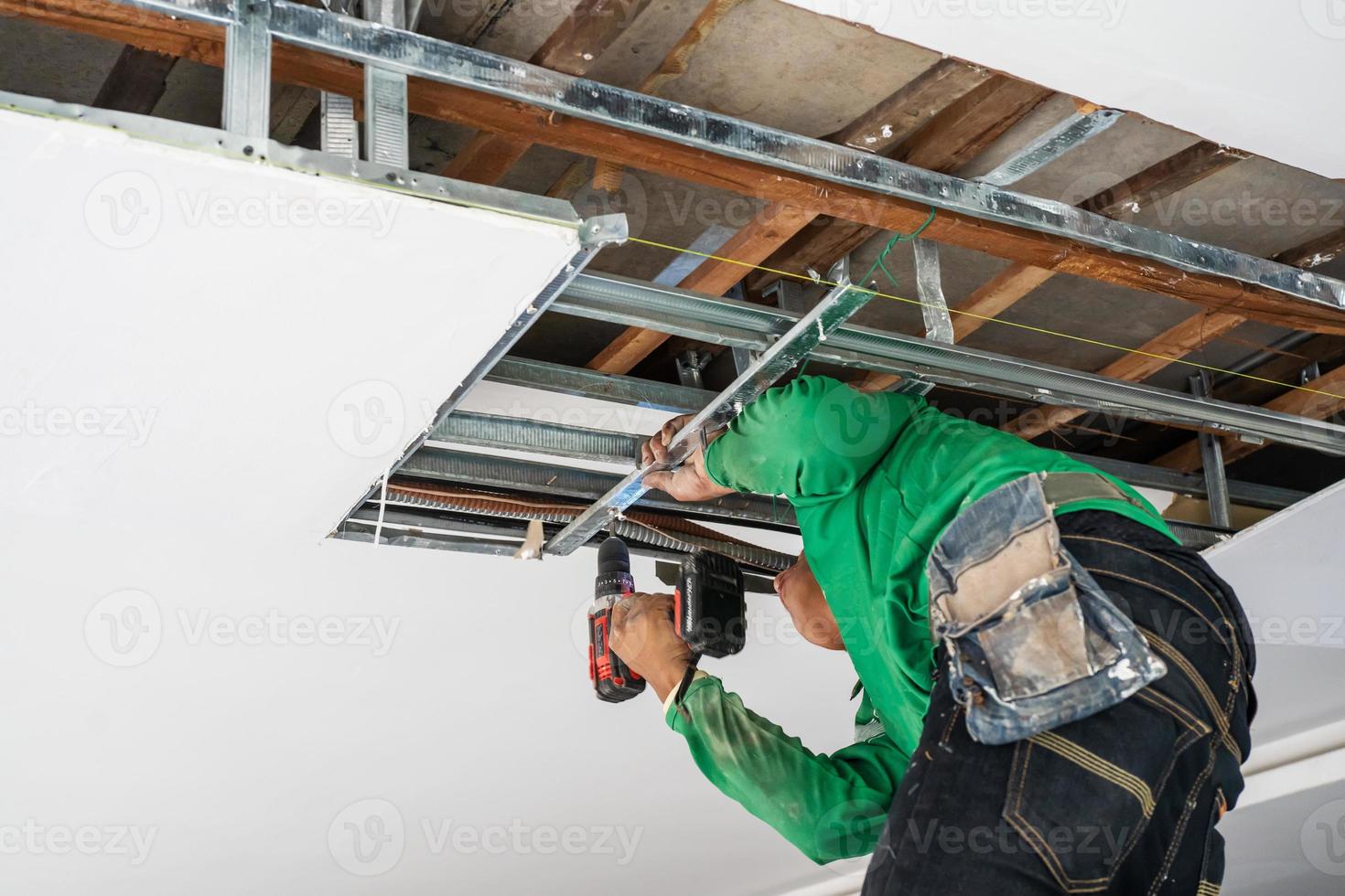 reparador reparando teto, painéis de teto quebrados e danos causados por vazamento de água, manutenção doméstica e conceito de casa de reparo. foto