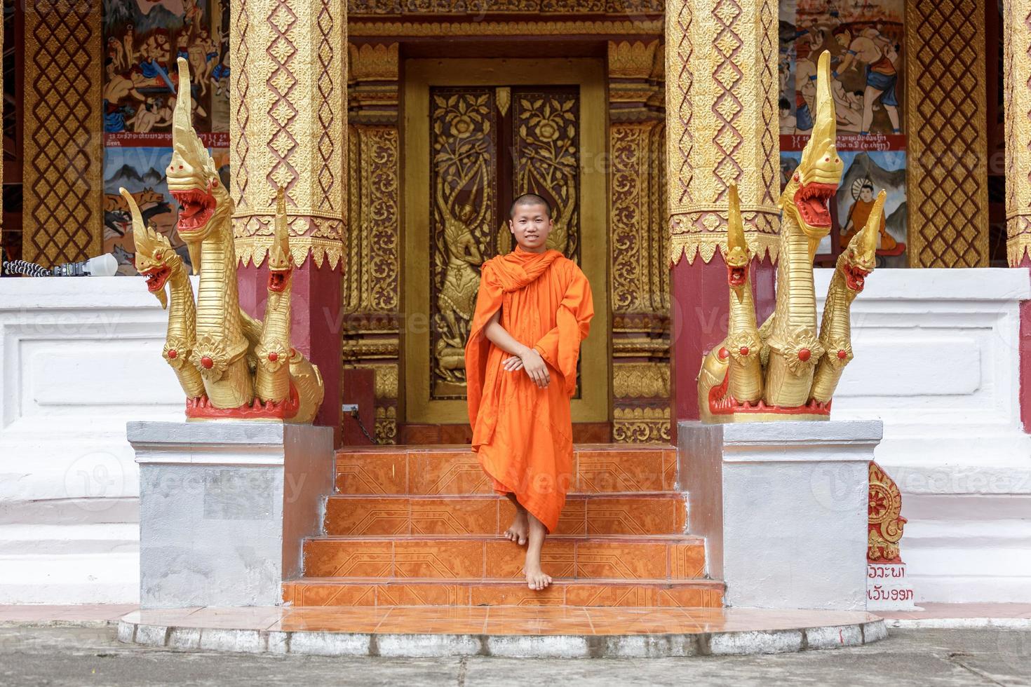 jovem monge budista andando na frente do mosteiro foto
