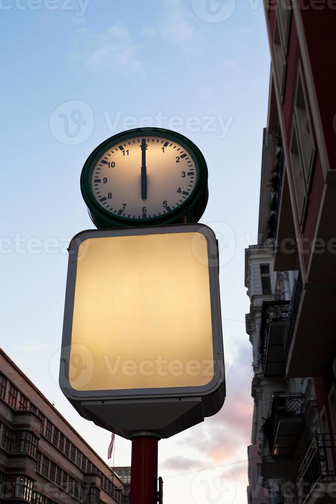 relógio de rua e outdoor de publicidade em branco foto