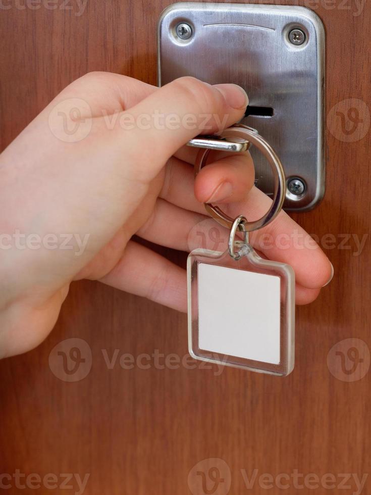 fechando a porta da casa por chave com chaveiro em branco foto