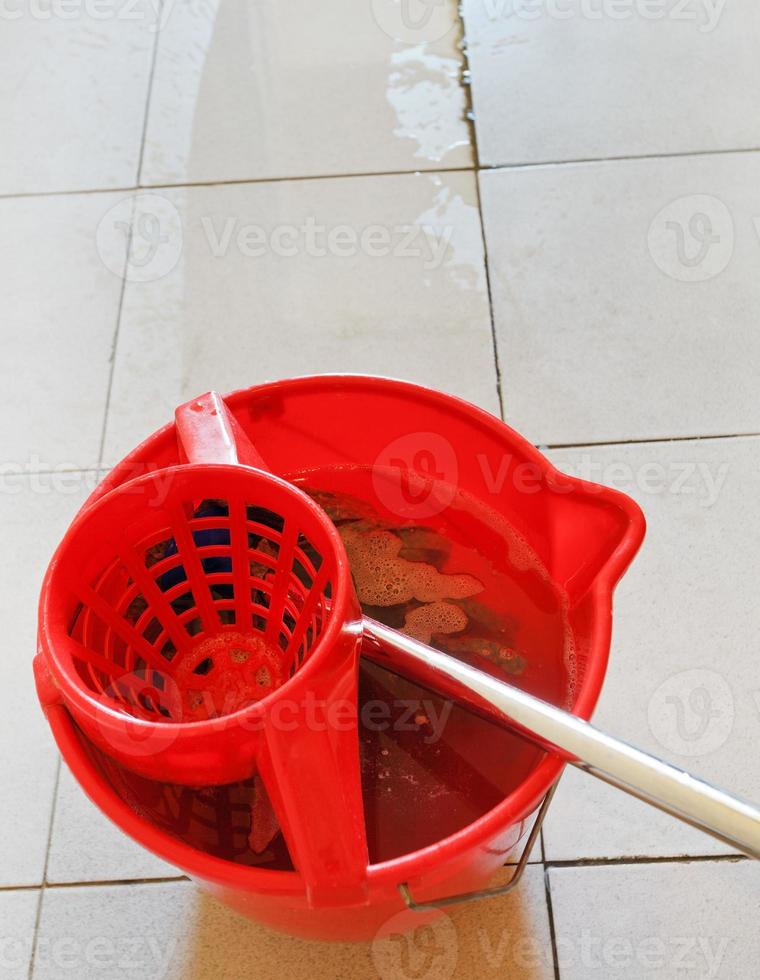 cotonete em balde vermelho com água de lavagem foto