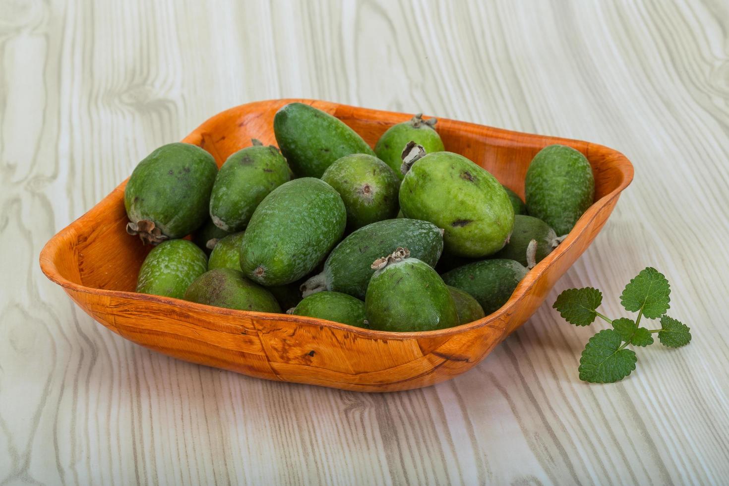 feijoa em uma tigela com fundo de madeira foto