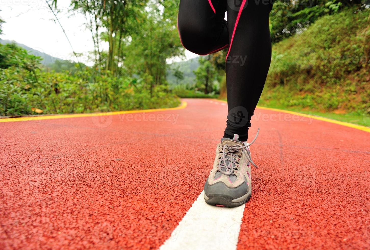 estilo de vida saudável fitness esportes pernas de mulher correndo na trilha do parque foto
