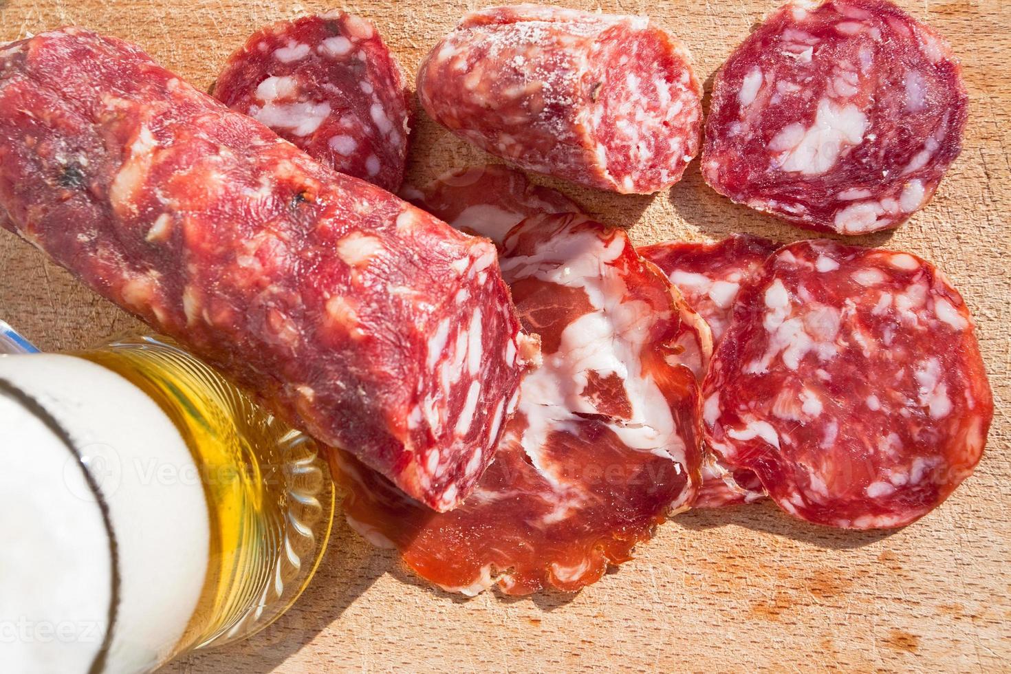 salame italiano e copo de cerveja foto