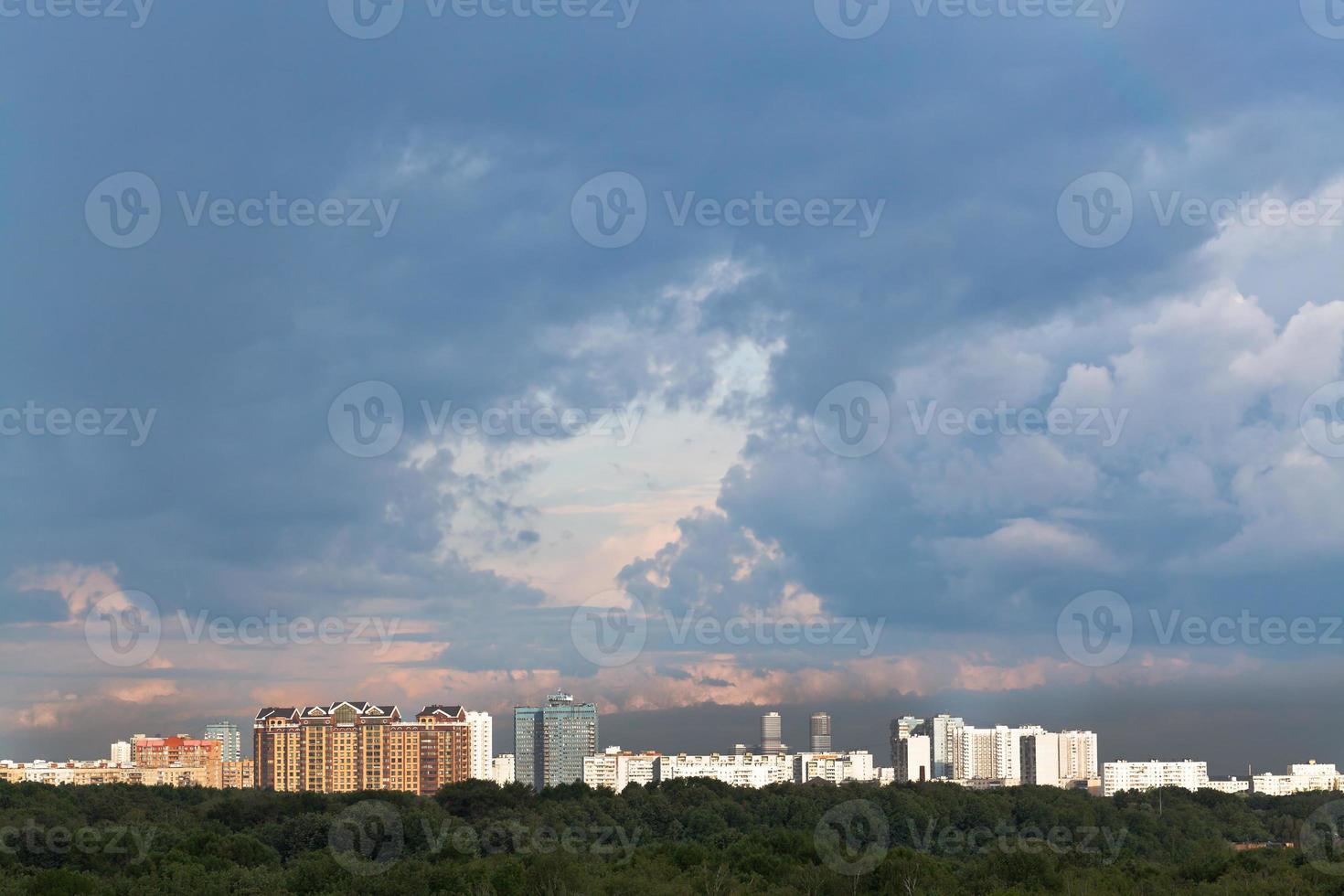 nuvens chuvosas escuras no céu pôr do sol sobre a cidade foto