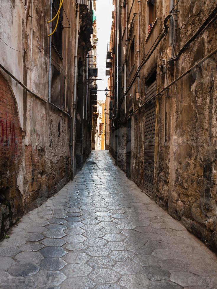 rua estreita com pavimento de pedra em palermo foto