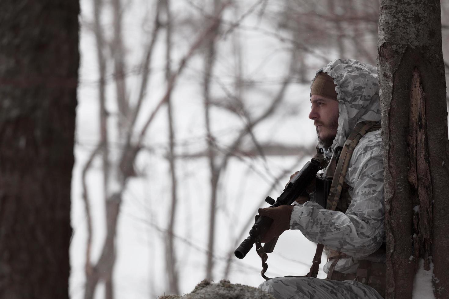 guerra de inverno nas montanhas árticas. operação em condições frias. soldado no uniforme camuflado de inverno no exército de guerra moderna em um dia de neve no campo de batalha da floresta com um rifle. foco seletivo foto