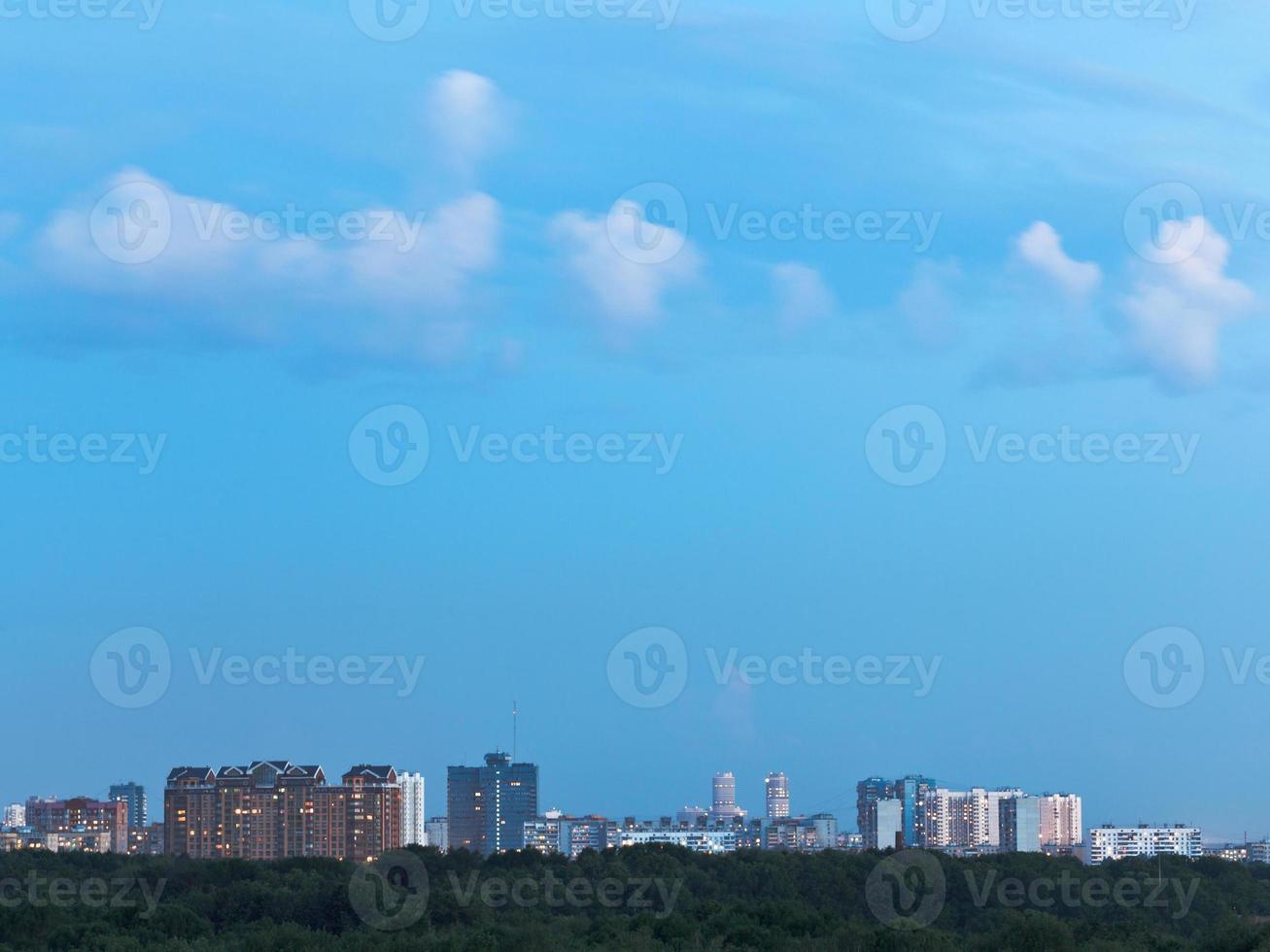 pequenas nuvens brancas no céu azul ao entardecer sobre a cidade foto