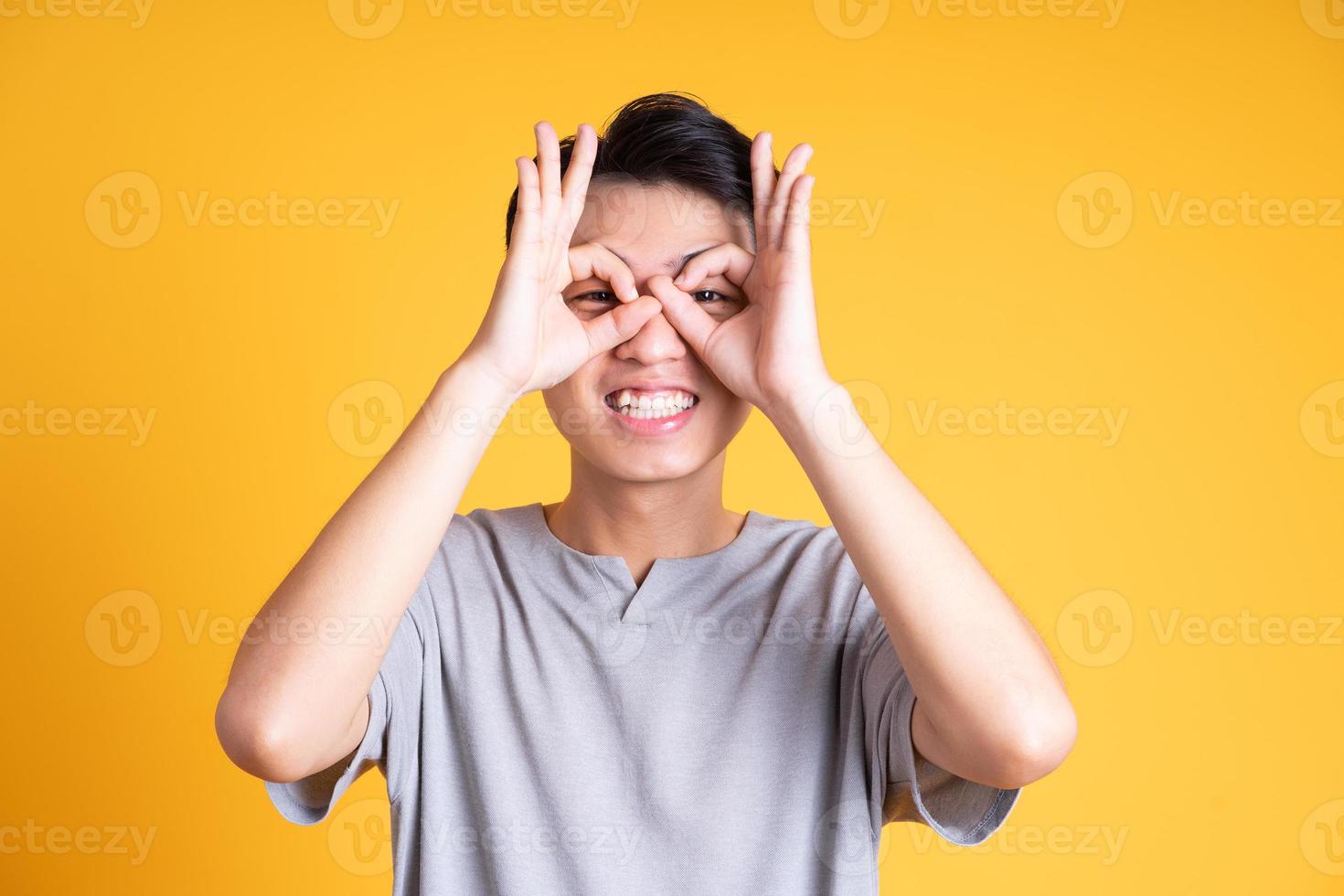 jovem asiático posando em um fundo amarelo foto