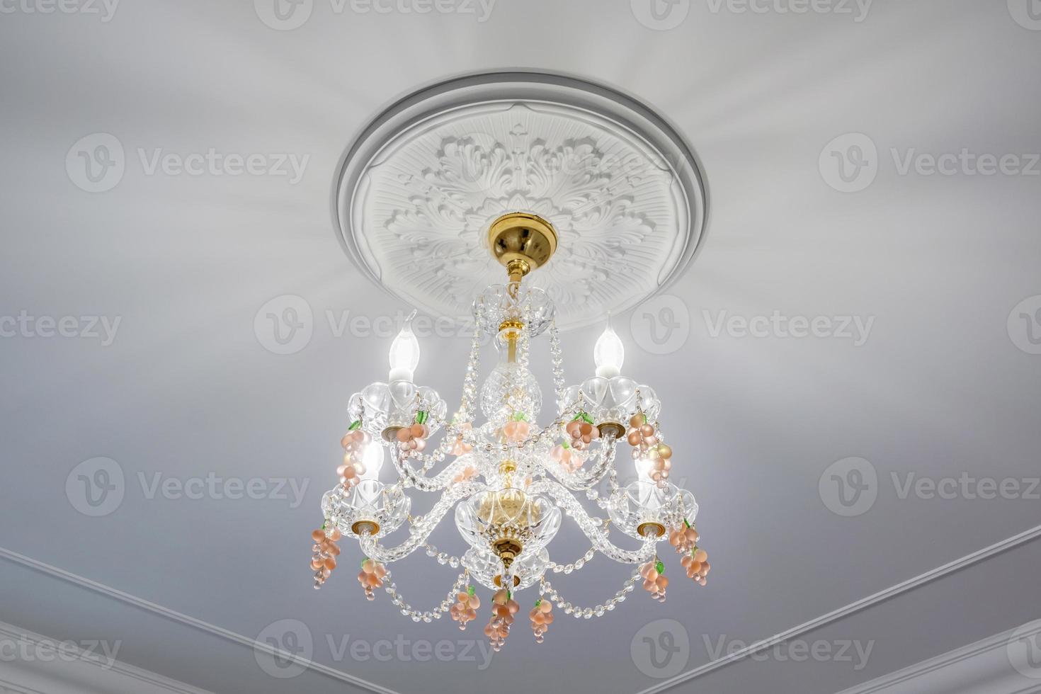 lustre elegante em um interior brilhante pendurado sob o teto no palácio, apartamento ou hotel foto