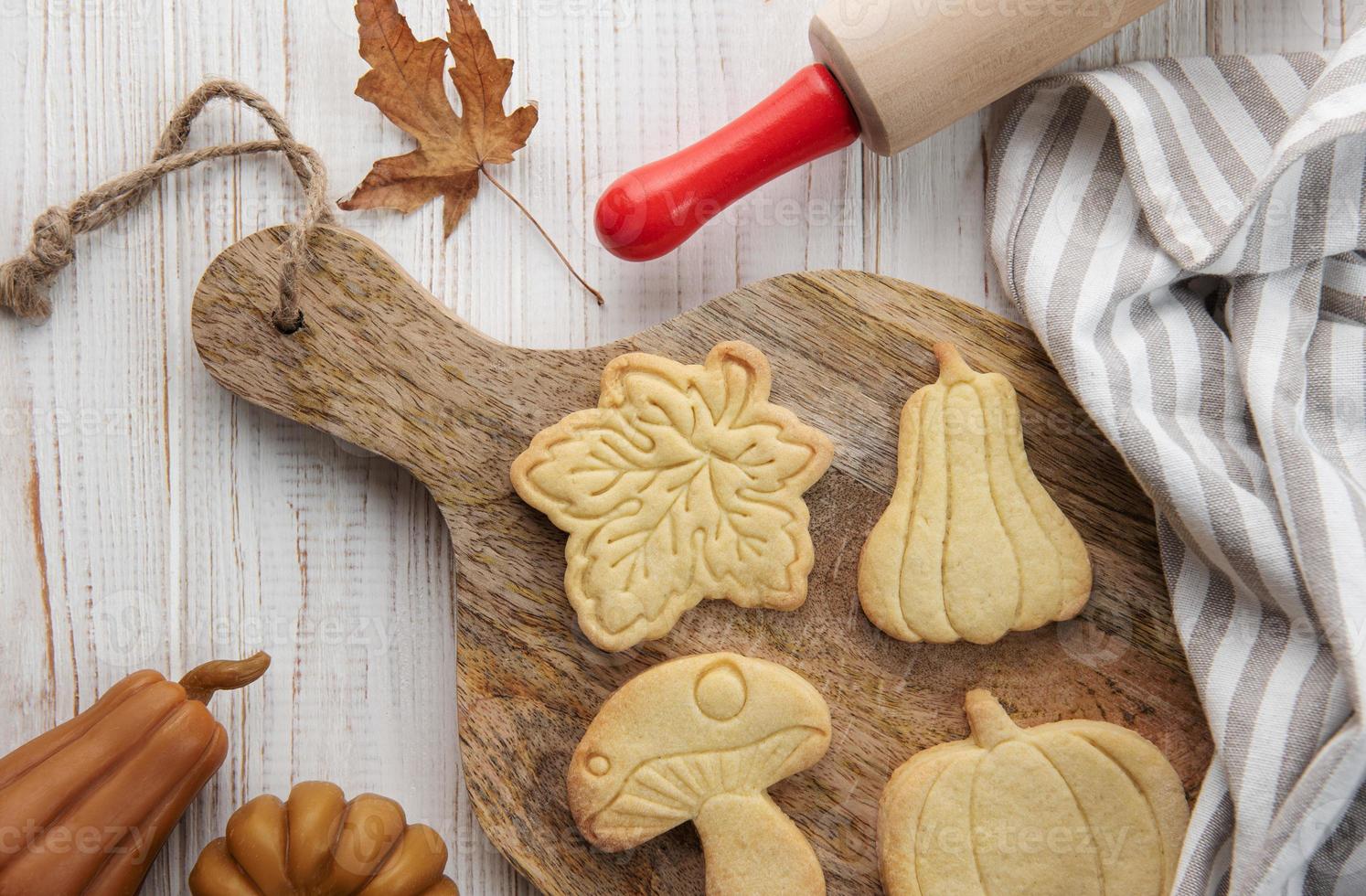 biscoitos em forma de abóbora e folhas em fundo de madeira rústica foto