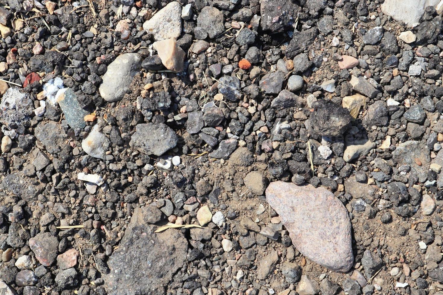 vista detalhada de perto em seixos e pedras em uma textura de terra de cascalho foto