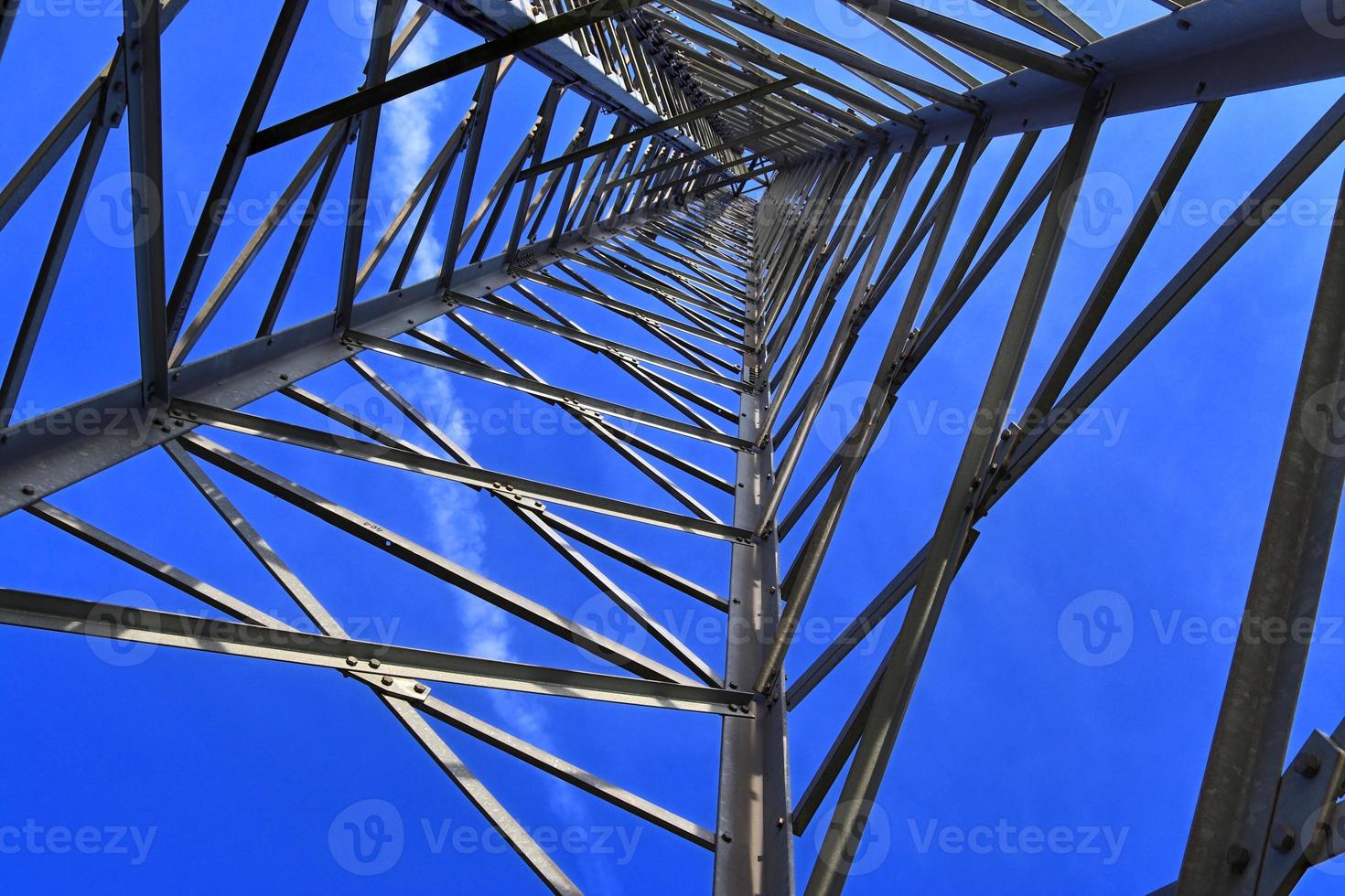 antena elétrica e torre transmissora de comunicação em uma paisagem do norte da Europa contra um céu azul foto