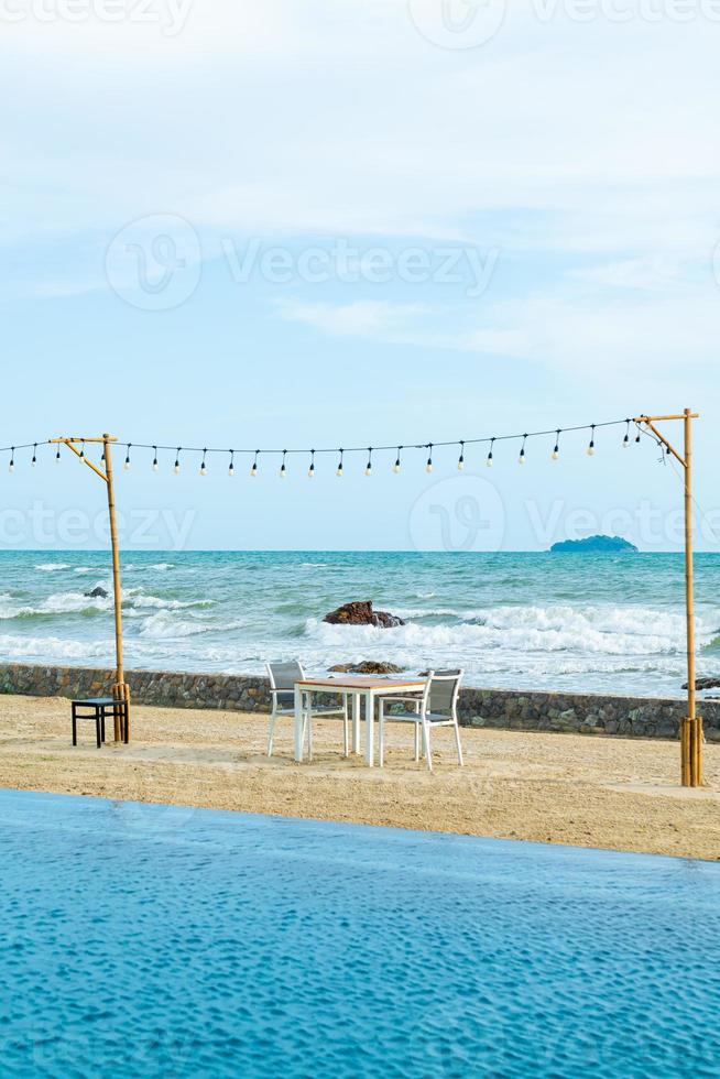 mesa de jantar e cadeira na praia com fundo do mar foto