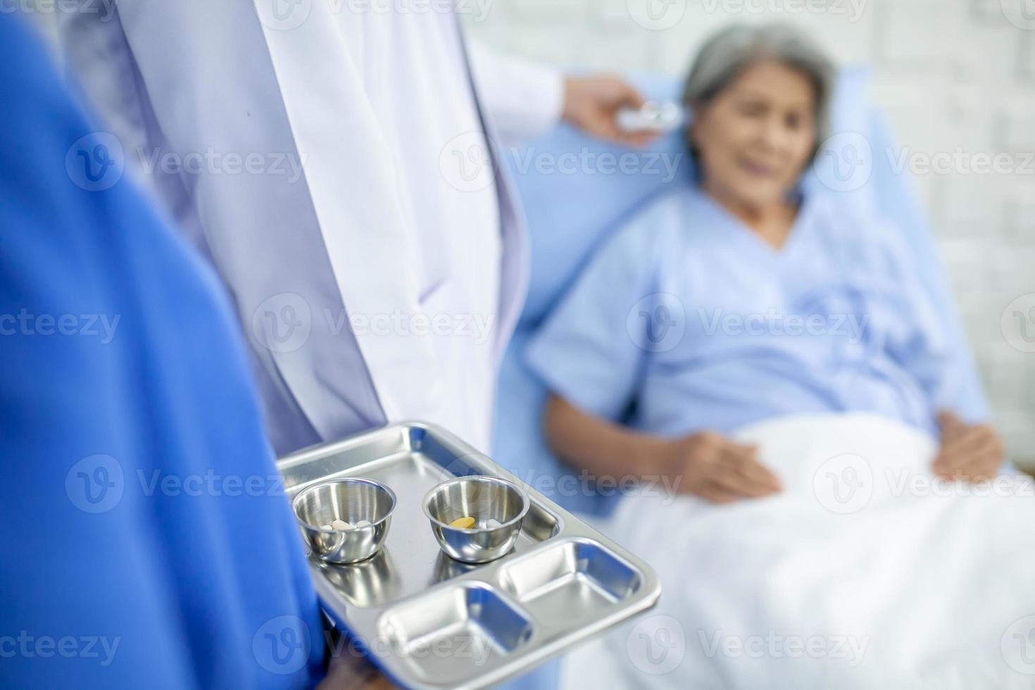 enfermeiras asiáticas estão dando remédios para pacientes idosos na sala de recuperação no conceito de hospital, saúde e medicina. foto