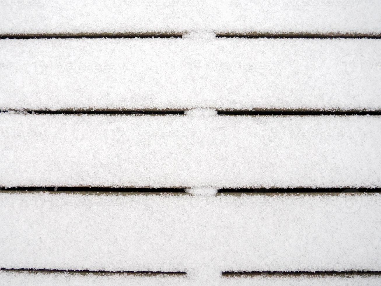 tábuas de madeira cobertas com uma fina camada de primeira neve. Primeira neve. foto