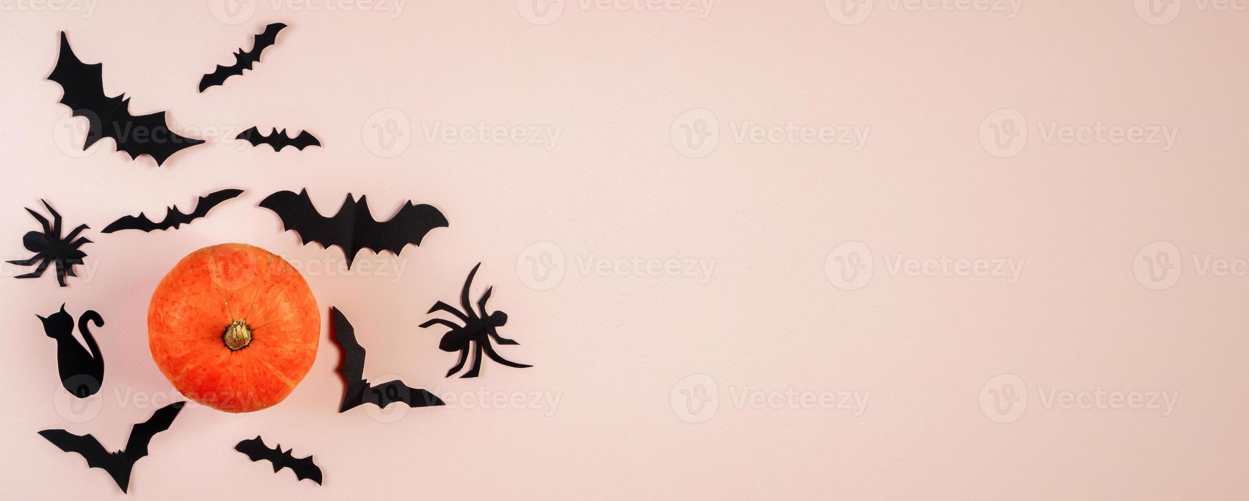 feliz Dia das Bruxas. morcegos e abóbora em fundo rosa pastel. foto