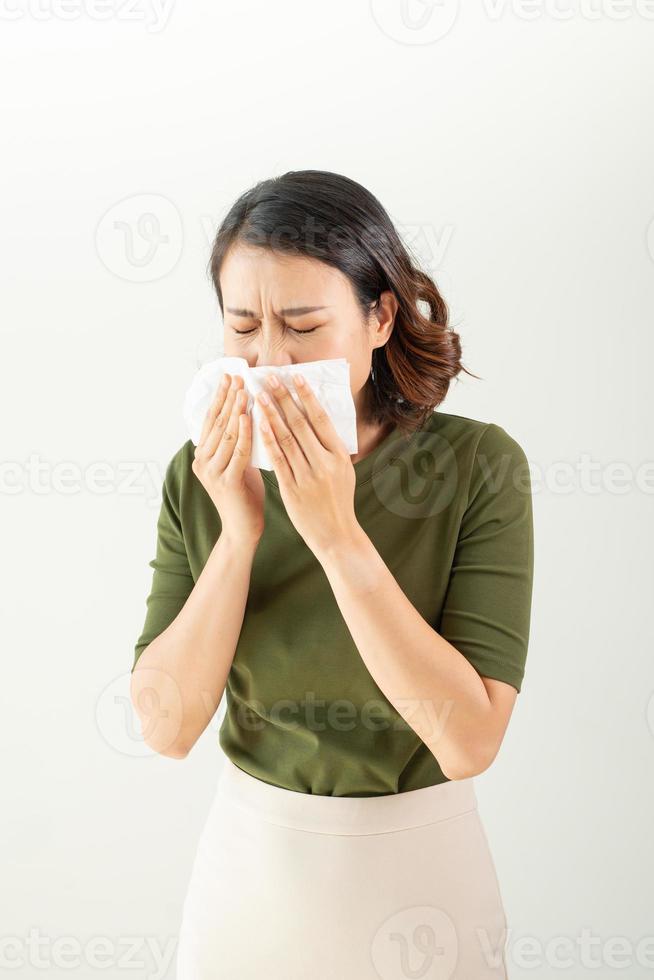 mulher com resfriado assoando o nariz escorrendo com tecido foto