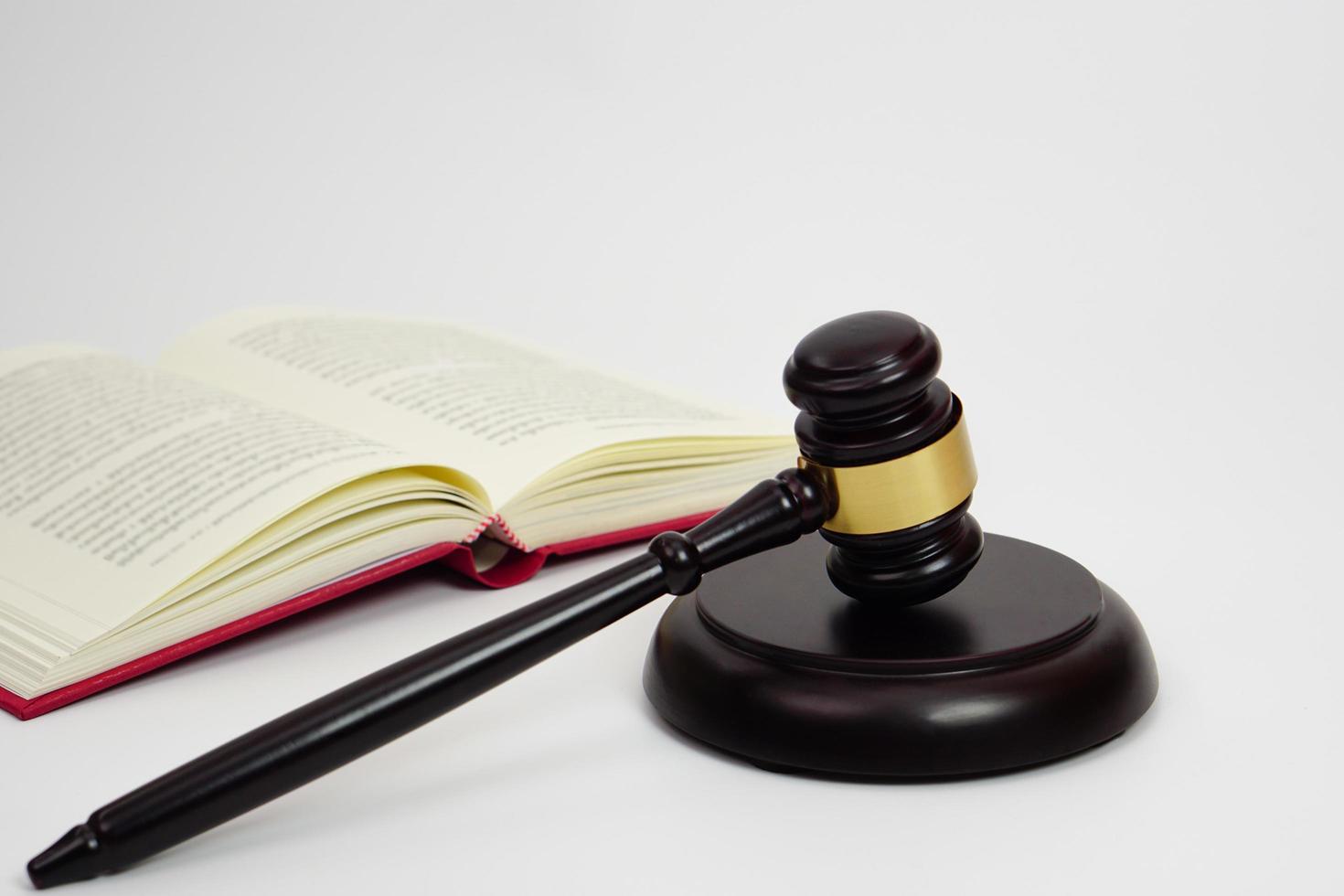 close-up de martelo de juiz, advogado, direito, justiça com livro de direito em segundo plano. foto