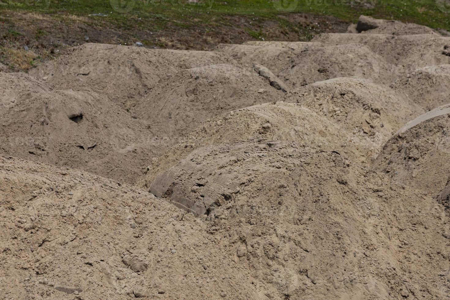 uma montanha de areia em um canteiro de obras. materiais de fundação. o solo é preparado para fortalecer o solo. monte de terra. areia fina para nivelamento e aterro foto