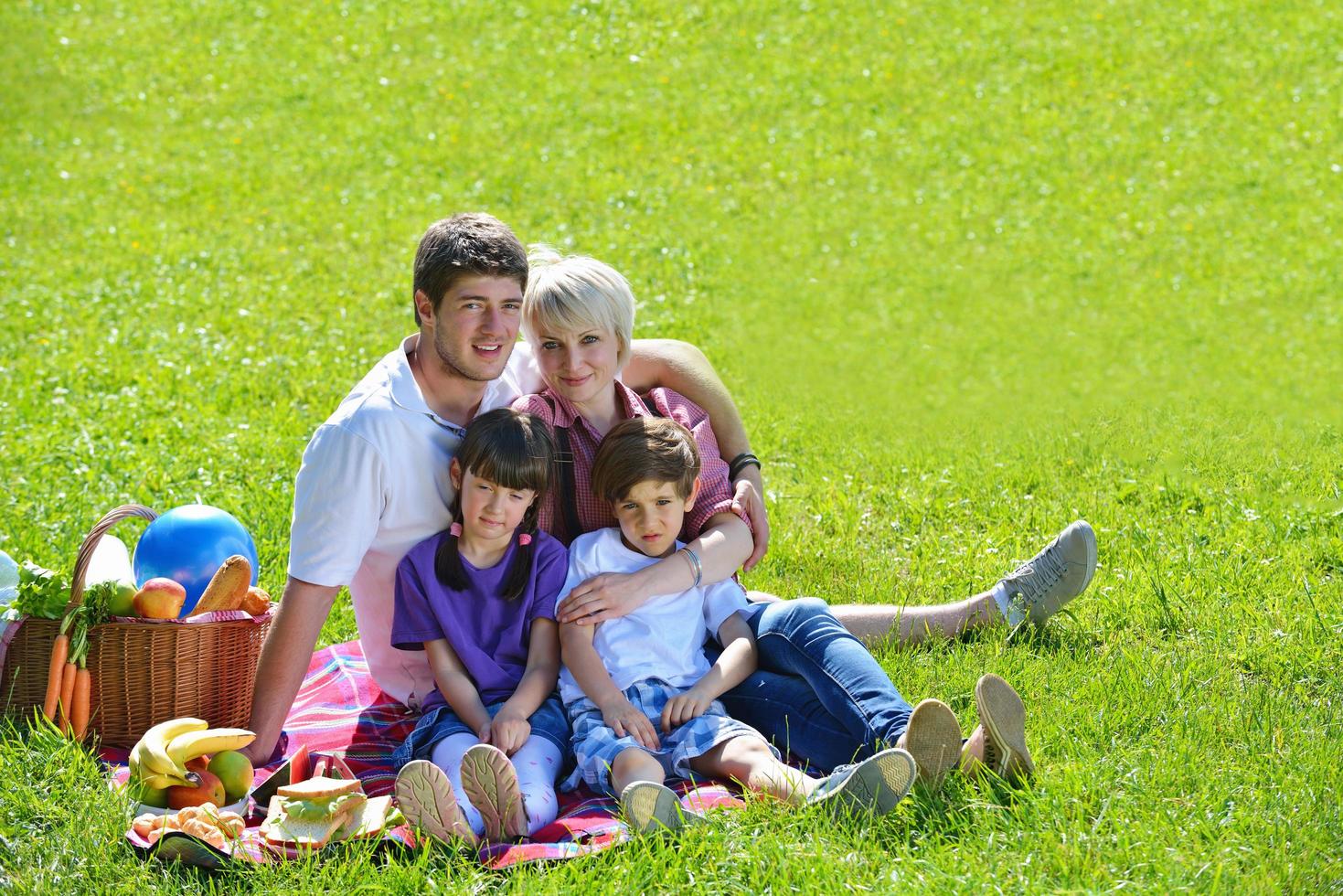 família feliz jogando juntos em um piquenique ao ar livre foto