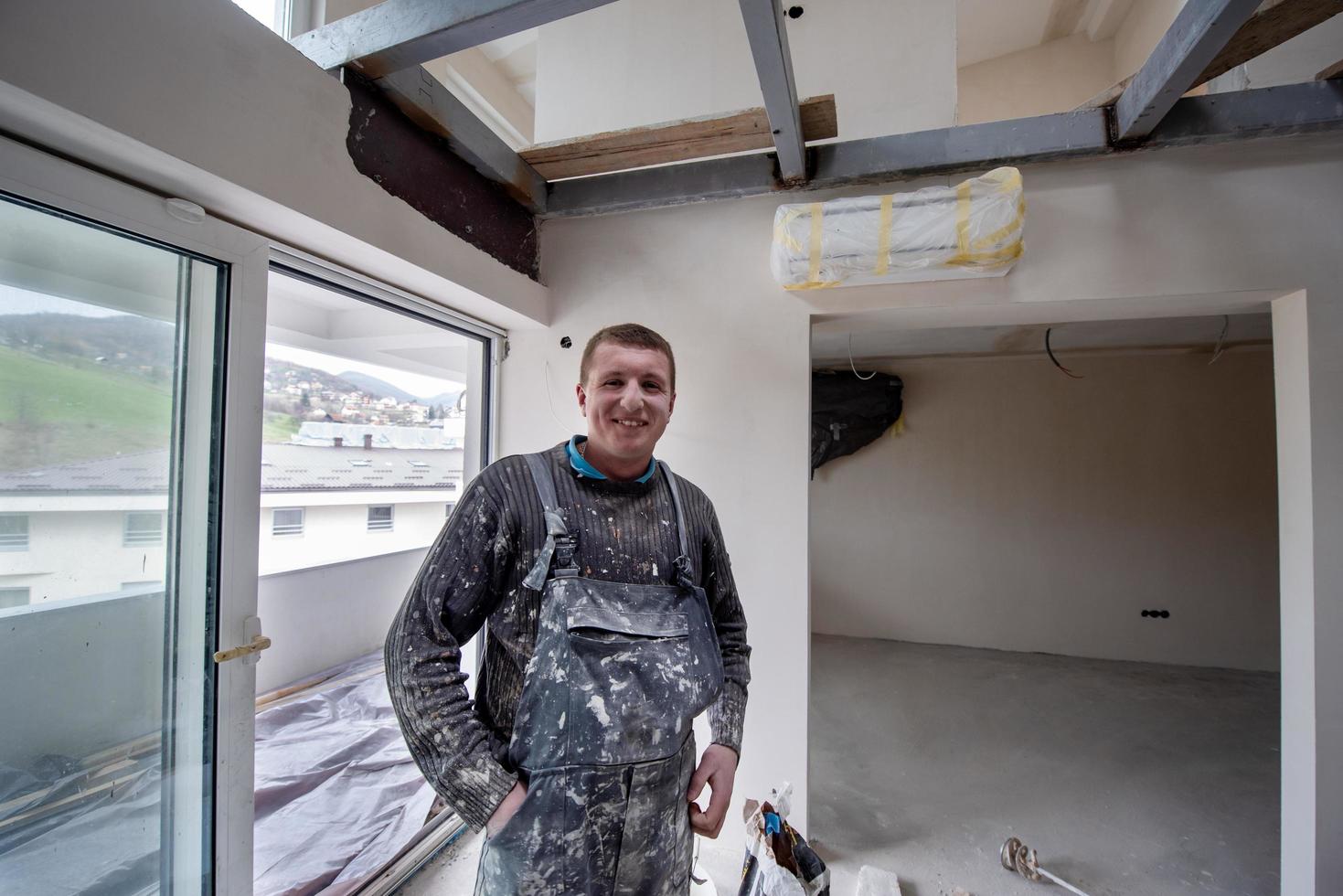 retrato de trabalhador da construção civil com uniforme sujo no apartamento foto