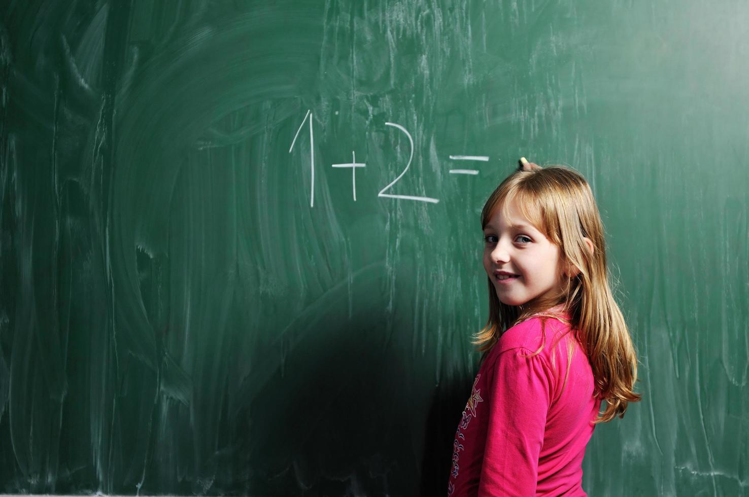 menina da escola feliz nas aulas de matemática foto