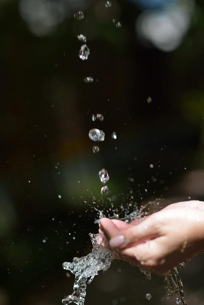 fluxo de água na mão da mulher foto