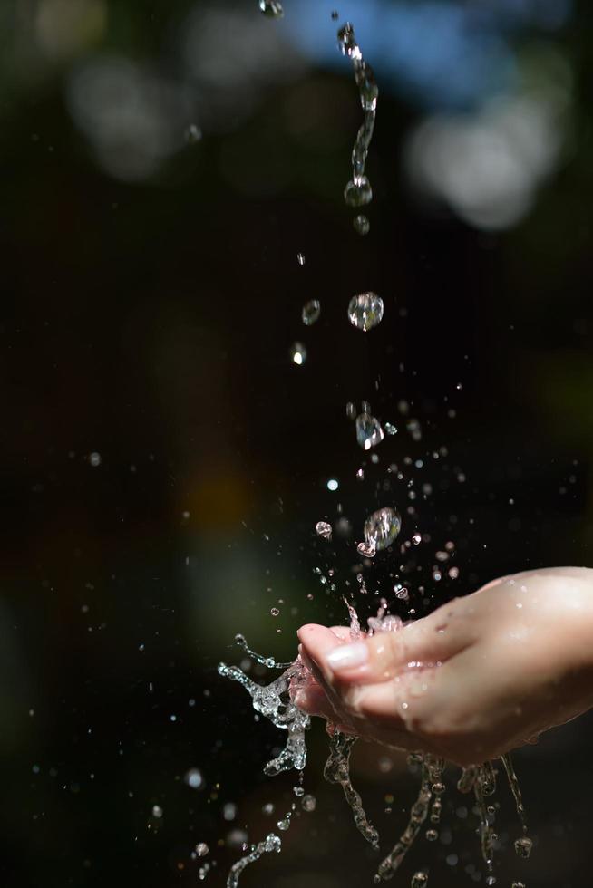 fluxo de água na mão da mulher foto