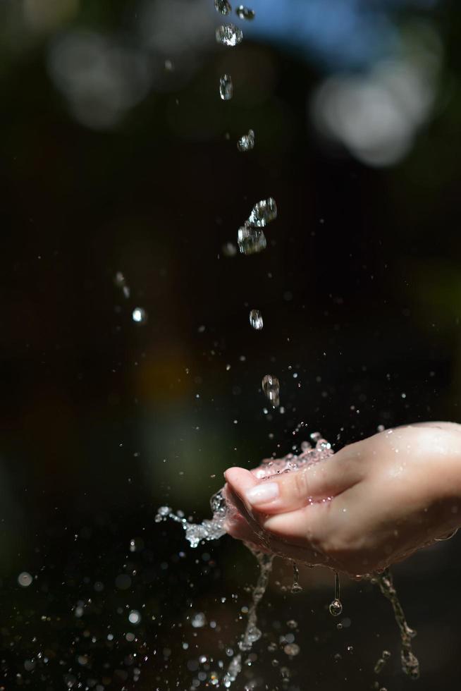 fluxo de água na mão da mulher foto