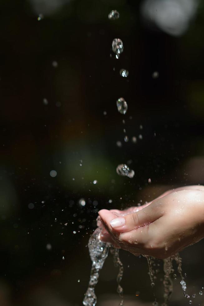 fluxo de água na mão da mulher foto